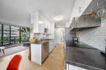 This modern kitchen boasts sleek white cabinetry, stainless steel appliances, and a stylish countertop.