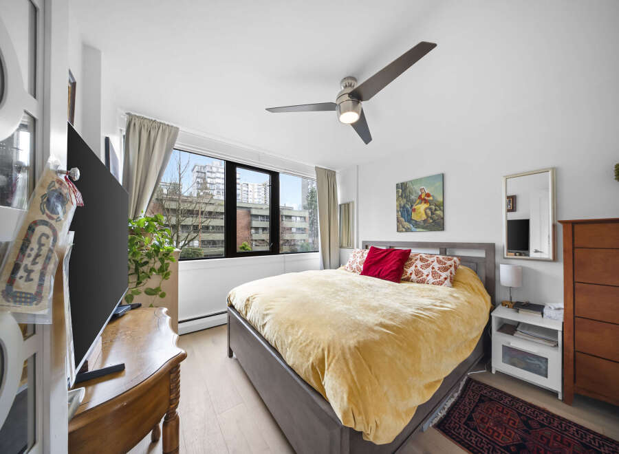 This bright and airy bedroom offers a serene retreat with its neutral color palette and ample natural light.