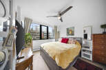 This bright and airy bedroom offers a serene retreat with its neutral color palette and ample natural light.