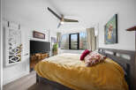 Step into this inviting bedroom, featuring a cozy bed adorned with plush pillows and a vibrant yellow comforter.