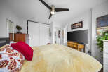 Step into this inviting bedroom, featuring a comfortable bed with a stylish red pillow and patterned bedding.