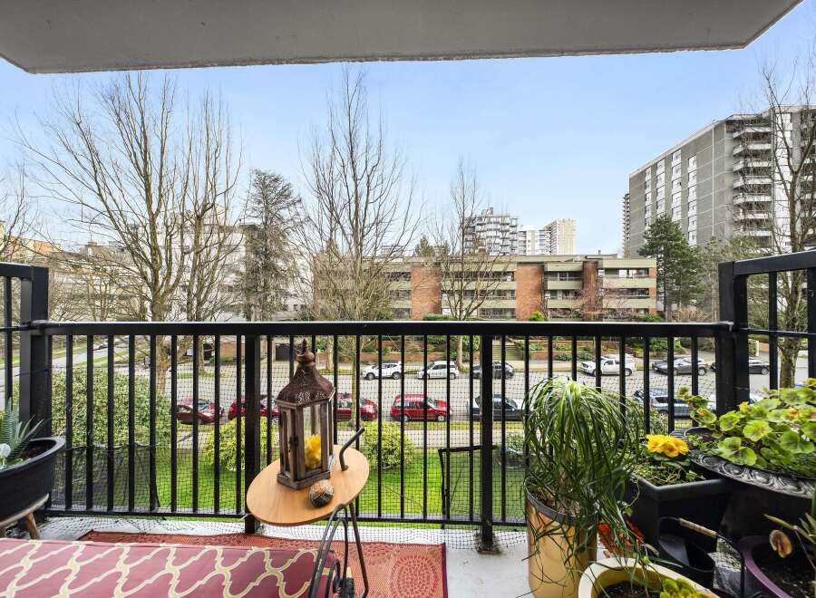 Enjoy stunning views from this beautiful balcony! This outdoor space features a charming table, lush greenery, and a cozy rug, perfect for relaxing or entertaining.