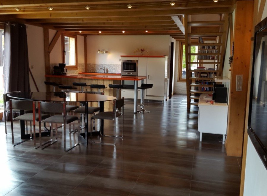 This stunning chalet boasts an open-plan living area with a sleek, modern kitchen and dining space.