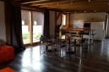 This stunning chalet boasts an open-plan living area with a sleek, modern kitchen and a large dining table perfect for entertaining.