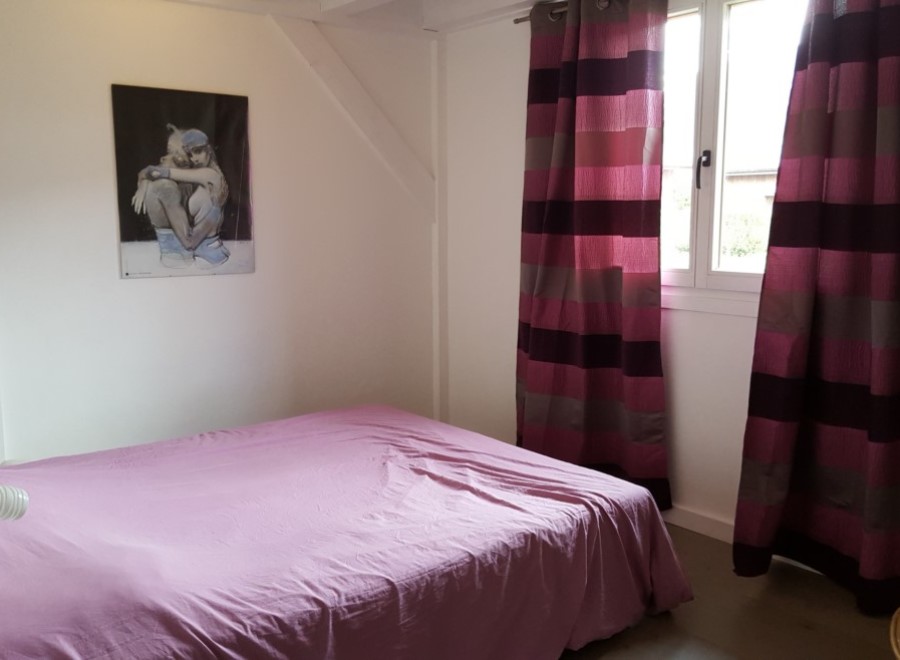 Cozy bedroom with a double bed and striped curtains.