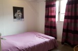 Cozy bedroom with a double bed and striped curtains.