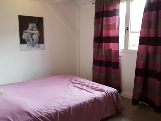 Cozy bedroom with a double bed and striped curtains.