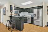 This stunning kitchen boasts modern appliances and sleek black cabinetry, perfect for any home chef.