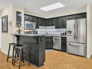 This stunning kitchen boasts modern appliances and sleek black cabinetry, perfect for any home chef.