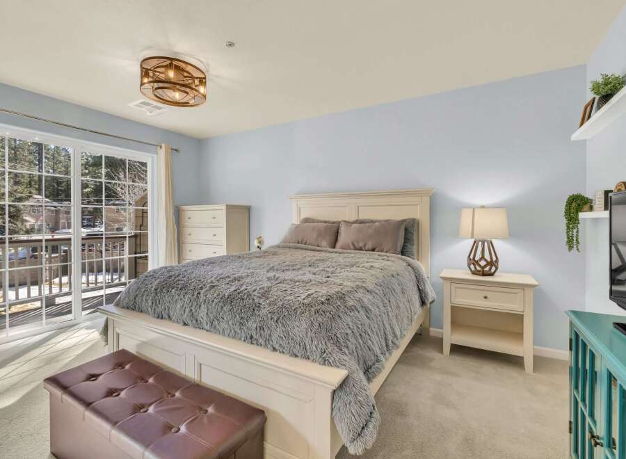 Step into this inviting bedroom, featuring a cozy bed adorned with a plush, textured blanket.