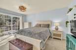 Step into this inviting bedroom, featuring a cozy bed adorned with a plush, textured blanket.