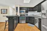 This stunning kitchen boasts modern appliances and sleek black cabinetry, perfect for culinary enthusiasts.