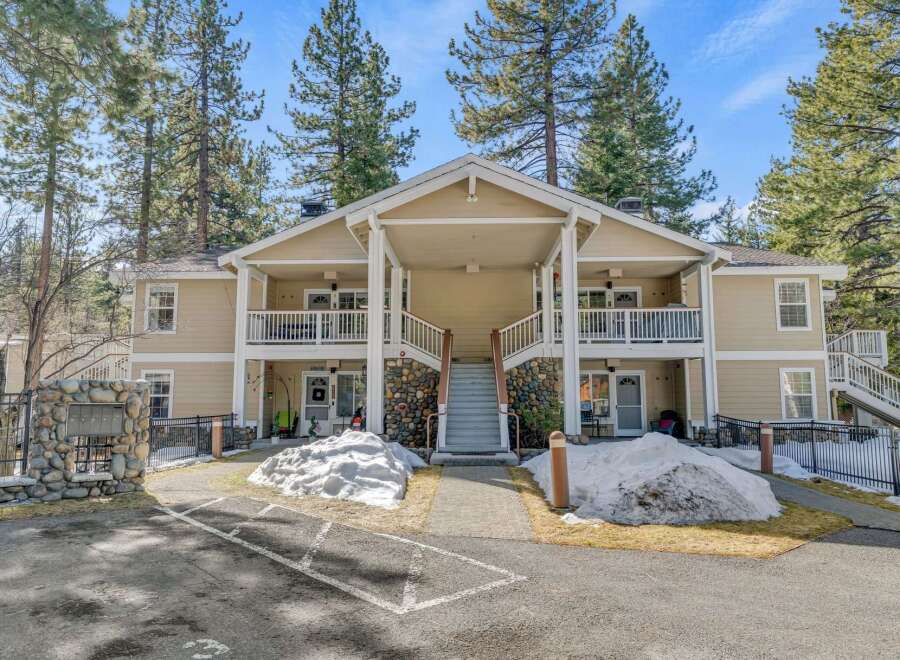 Discover a charming two-story building nestled amidst towering trees, offering a serene living experience.