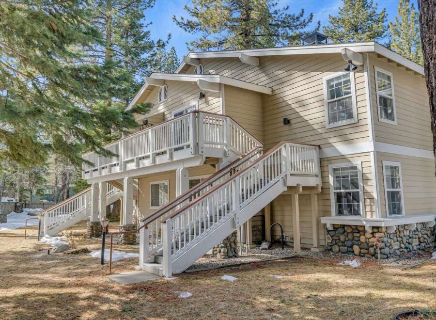 This charming two-story home boasts a beautiful exterior with a welcoming deck and staircase.