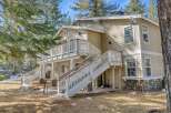 This charming two-story home boasts a beautiful exterior with a welcoming deck and staircase.