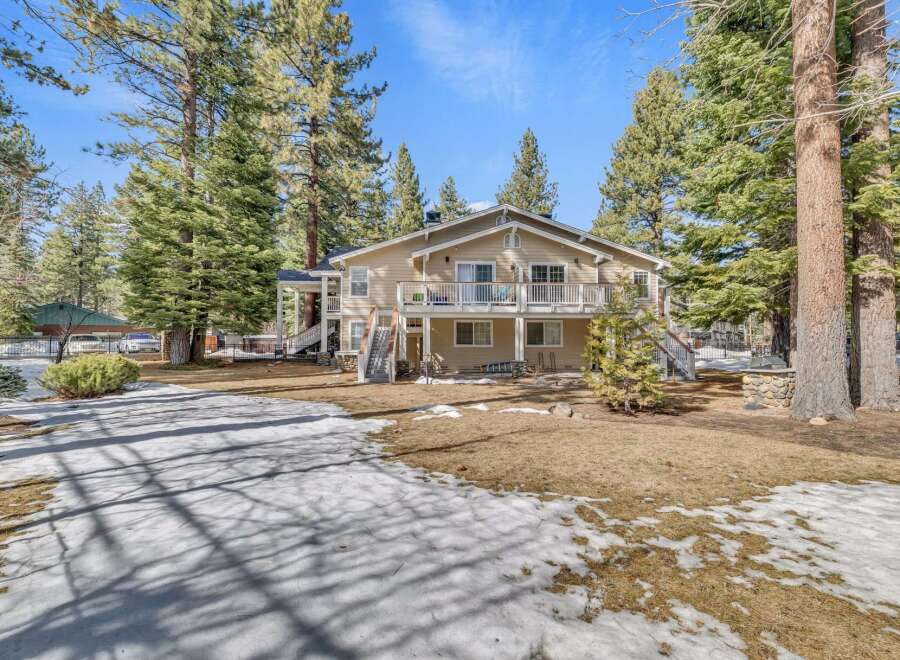 Nestled amidst towering trees, this stunning two-story home offers a serene retreat.