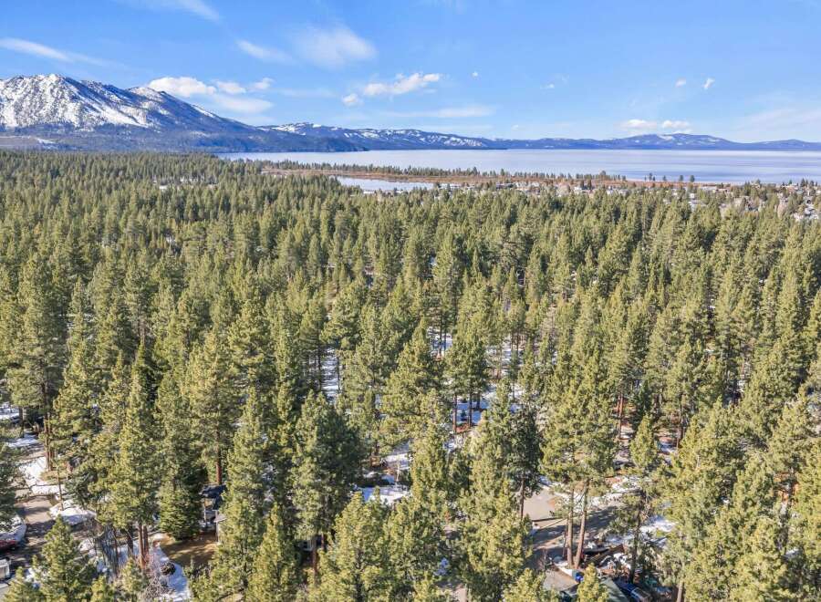 Discover the tranquility of this stunning property nestled amidst a lush forest, offering breathtaking views of the lake and snow-capped mountains.