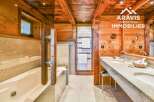 Experience luxury in this stunning bathroom featuring a beautiful wooden ceiling and walls, creating a warm and inviting atmosphere.