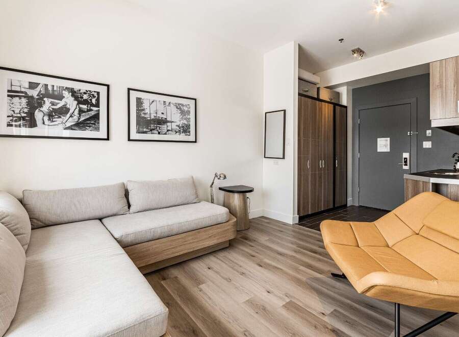 Discover modern living in this stylish apartment! Featuring a comfortable sectional sofa, a unique accent chair, and sleek hardwood floors, this space is perfect for relaxation and entertaining.