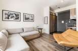 Discover modern living in this stylish apartment! Featuring a comfortable sectional sofa, a unique accent chair, and sleek hardwood floors, this space is perfect for relaxation and entertaining.