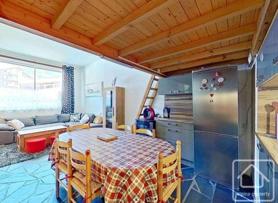 Discover this charming property featuring a cozy dining area with a rustic wooden table and chairs.