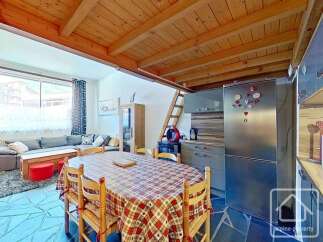 Discover this charming property featuring a cozy dining area with a rustic wooden table and chairs.