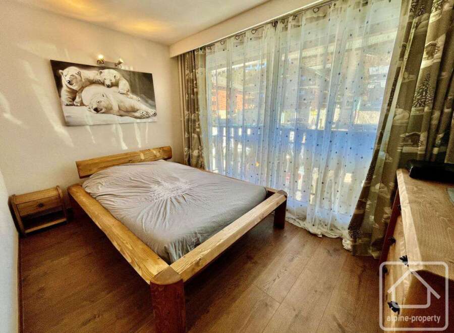 This cozy bedroom features a rustic wooden bed frame, creating a warm and inviting atmosphere.