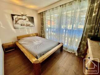 This cozy bedroom features a rustic wooden bed frame, creating a warm and inviting atmosphere.