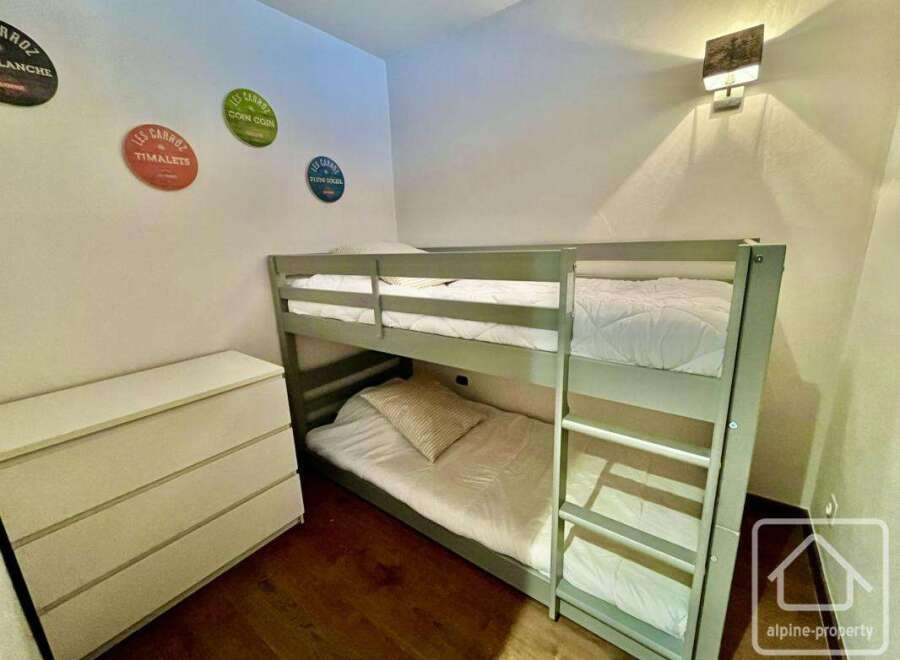 Discover this charming bedroom featuring a cozy bunk bed, perfect for accommodating guests or family members.