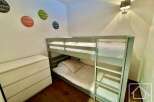 Discover this charming bedroom featuring a cozy bunk bed, perfect for accommodating guests or family members.