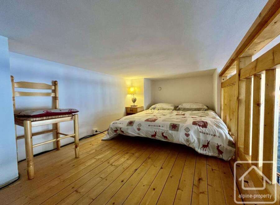 Discover this charming property featuring a cozy bedroom with a comfortable bed and unique wooden accents.