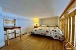 Discover this charming property featuring a cozy bedroom with a comfortable bed and unique wooden accents.