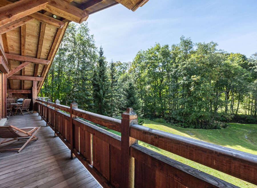 Enjoy the tranquility of nature from this stunning wooden balcony.