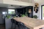 This modern kitchen boasts a stunning wooden island, perfect for both cooking and entertaining.