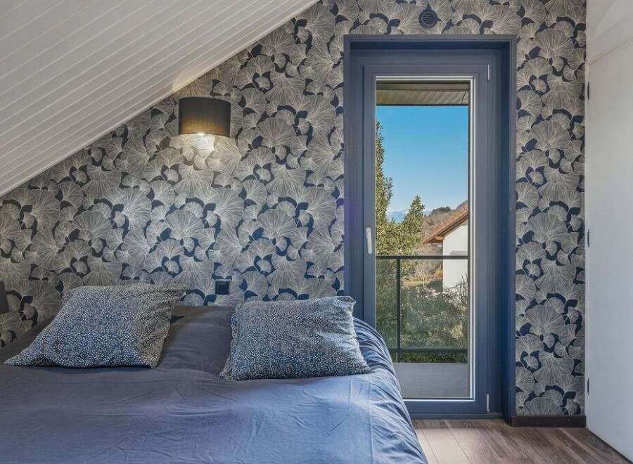 This stunning bedroom boasts a unique design with patterned wallpaper and a cozy ambiance.