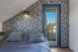 This stunning bedroom boasts a unique design with patterned wallpaper and a cozy ambiance.