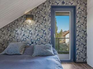 This stunning bedroom boasts a unique design with patterned wallpaper and a cozy ambiance.