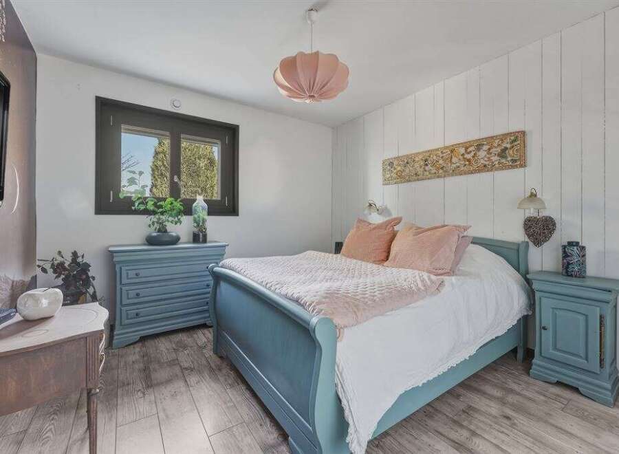 This charming bedroom features a cozy ambiance with its soft color palette and inviting decor.
