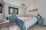 This charming bedroom features a cozy ambiance with its soft color palette and inviting decor.