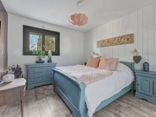 This charming bedroom features a cozy ambiance with its soft color palette and inviting decor.