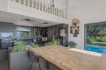 This stunning kitchen boasts a modern design with sleek, dark cabinetry and a spacious wooden island, perfect for both cooking and entertaining.