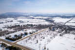 This stunning aerial view showcases a picturesque winter landscape, perfect for those seeking a serene rural retreat.