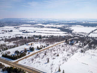 This stunning aerial view showcases a picturesque winter landscape, perfect for those seeking a serene rural retreat.