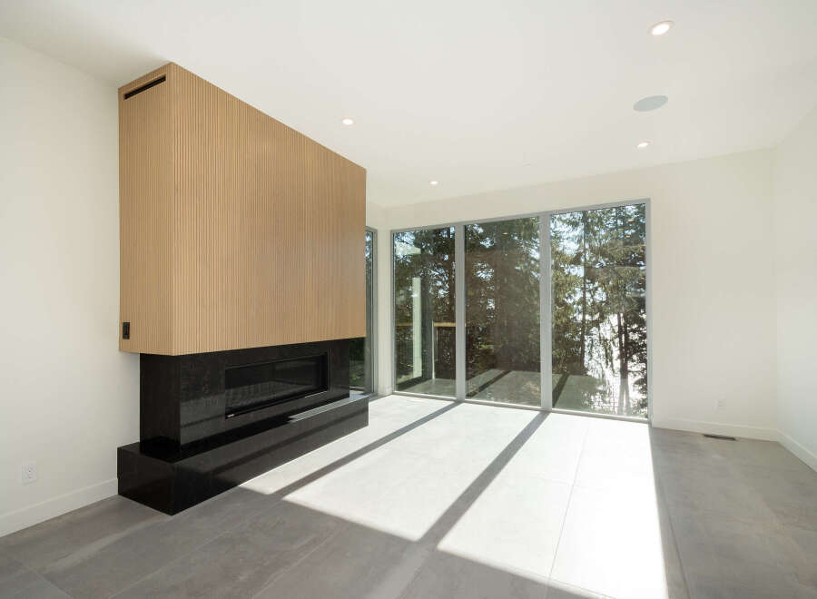 This stunning modern living space features a sleek fireplace with a wood panel design, creating a warm and inviting atmosphere.