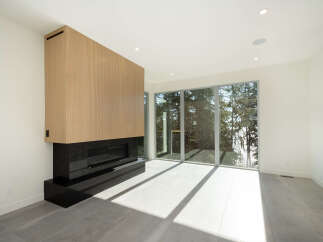 This stunning modern living space features a sleek fireplace with a wood panel design, creating a warm and inviting atmosphere.