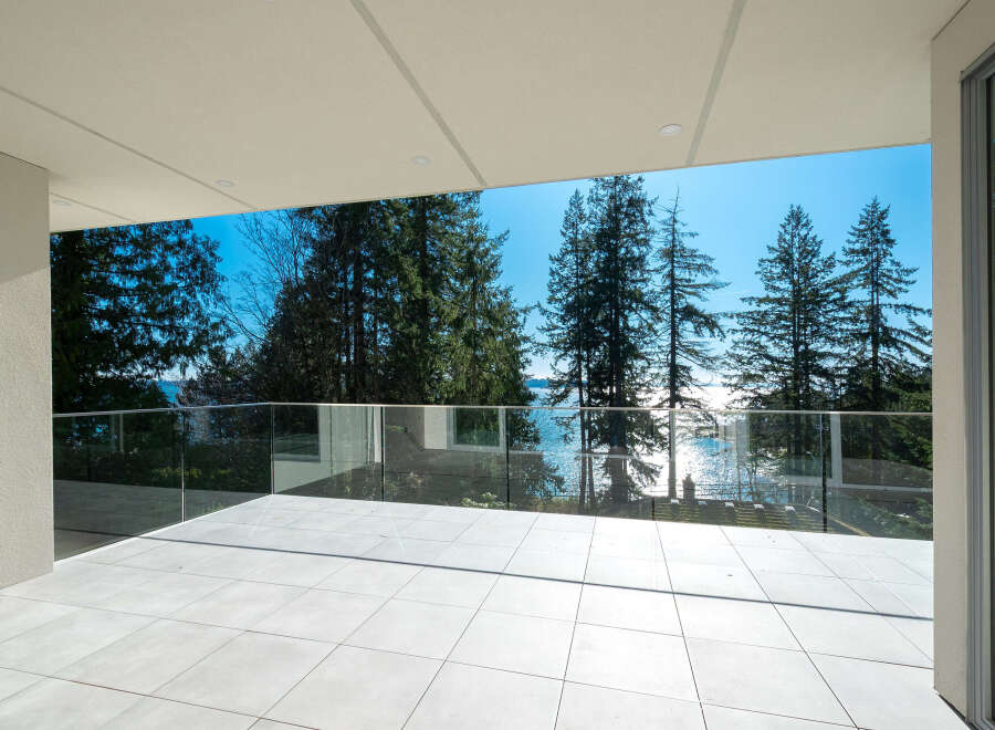 Experience breathtaking views from this stunning property! This modern home features a spacious balcony with glass railings, perfect for enjoying the surrounding natural beauty.