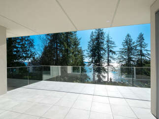 Experience breathtaking views from this stunning property! This modern home features a spacious balcony with glass railings, perfect for enjoying the surrounding natural beauty.