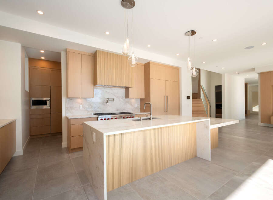 This stunning modern kitchen boasts sleek cabinetry, a spacious island, and high-end appliances.