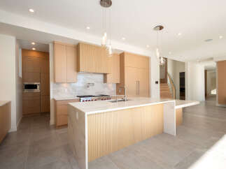 This stunning modern kitchen boasts sleek cabinetry, a spacious island, and high-end appliances.