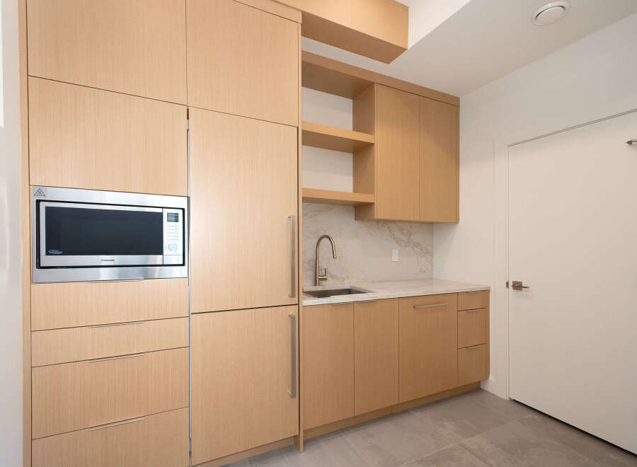 This modern kitchen boasts sleek cabinetry and a built-in microwave, perfect for contemporary living.